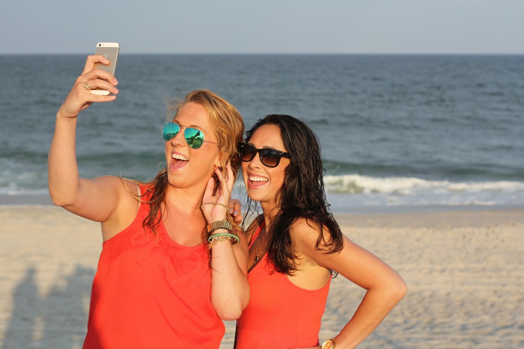 Girls on the beach taking pictures